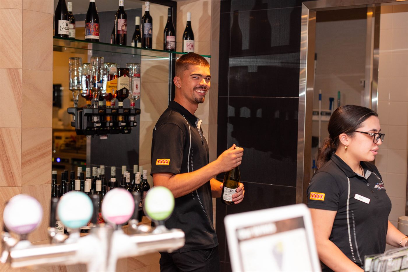 Friendly bar staff pouring a cold one