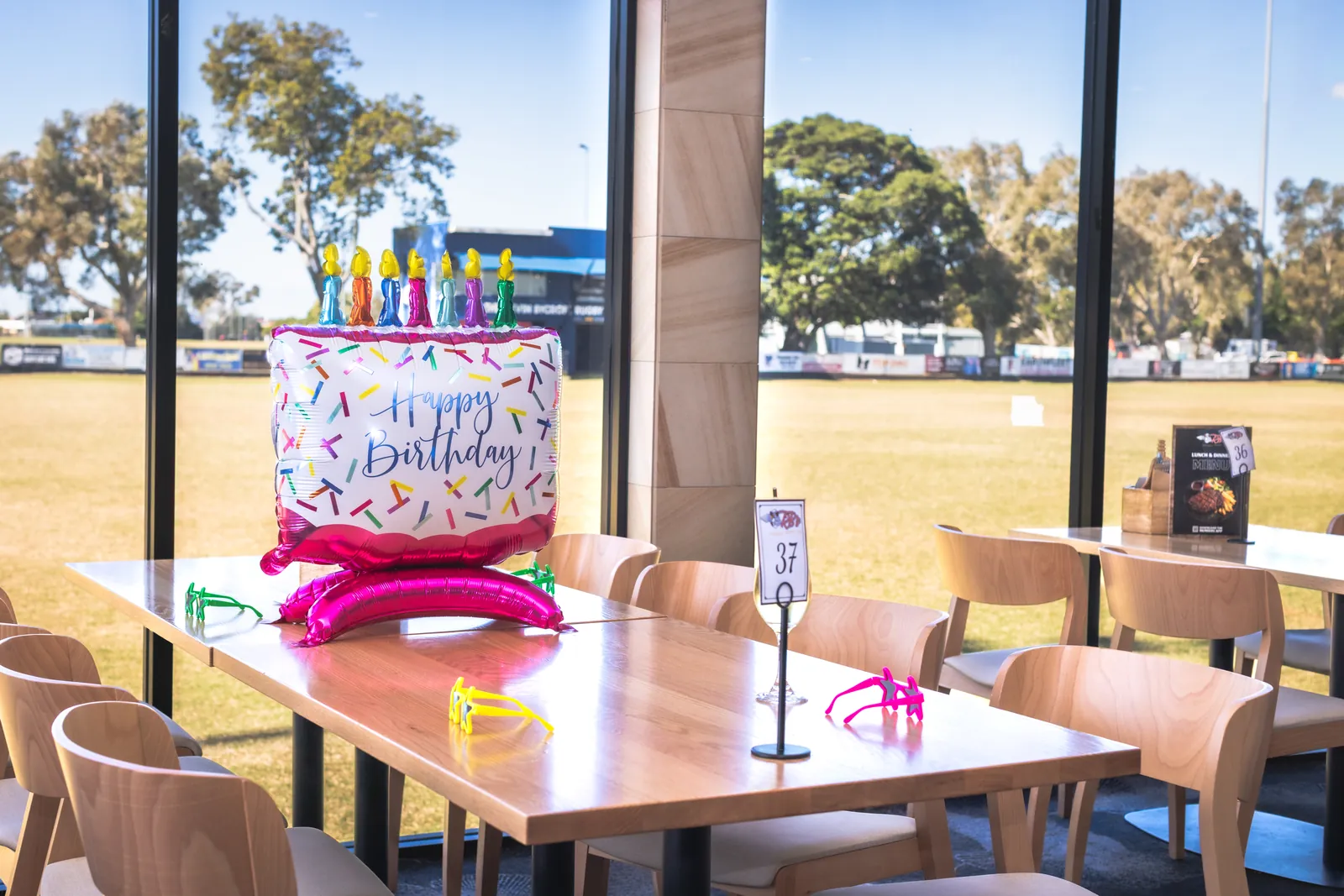 A birthday table setting in the function space, with the home ground through the windows