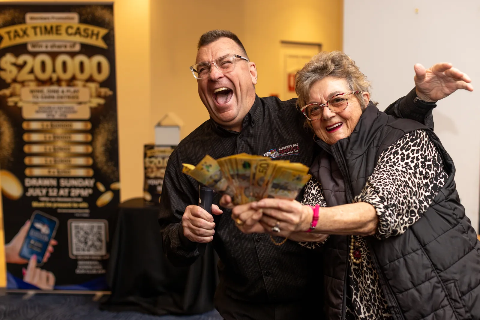 A delighted members draw winner holding her cash prize